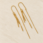 Gold-tone pair of dangle chain earrings on a light stone surface