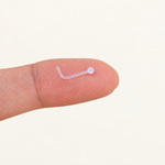 Clear L-shaped nose stud retainer held on a fingertip