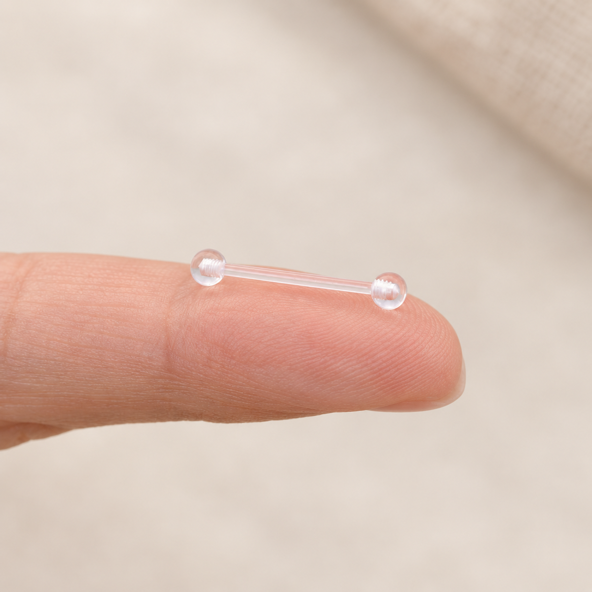 Clear nipple retainer held between fingers