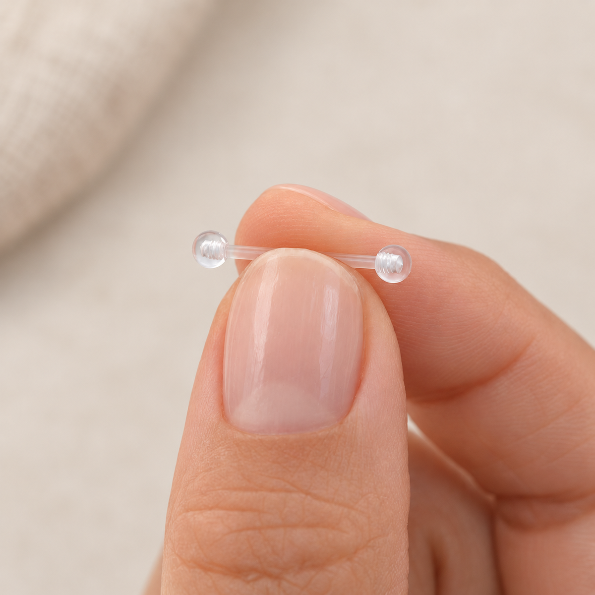 Clear nipple retainer held between fingers