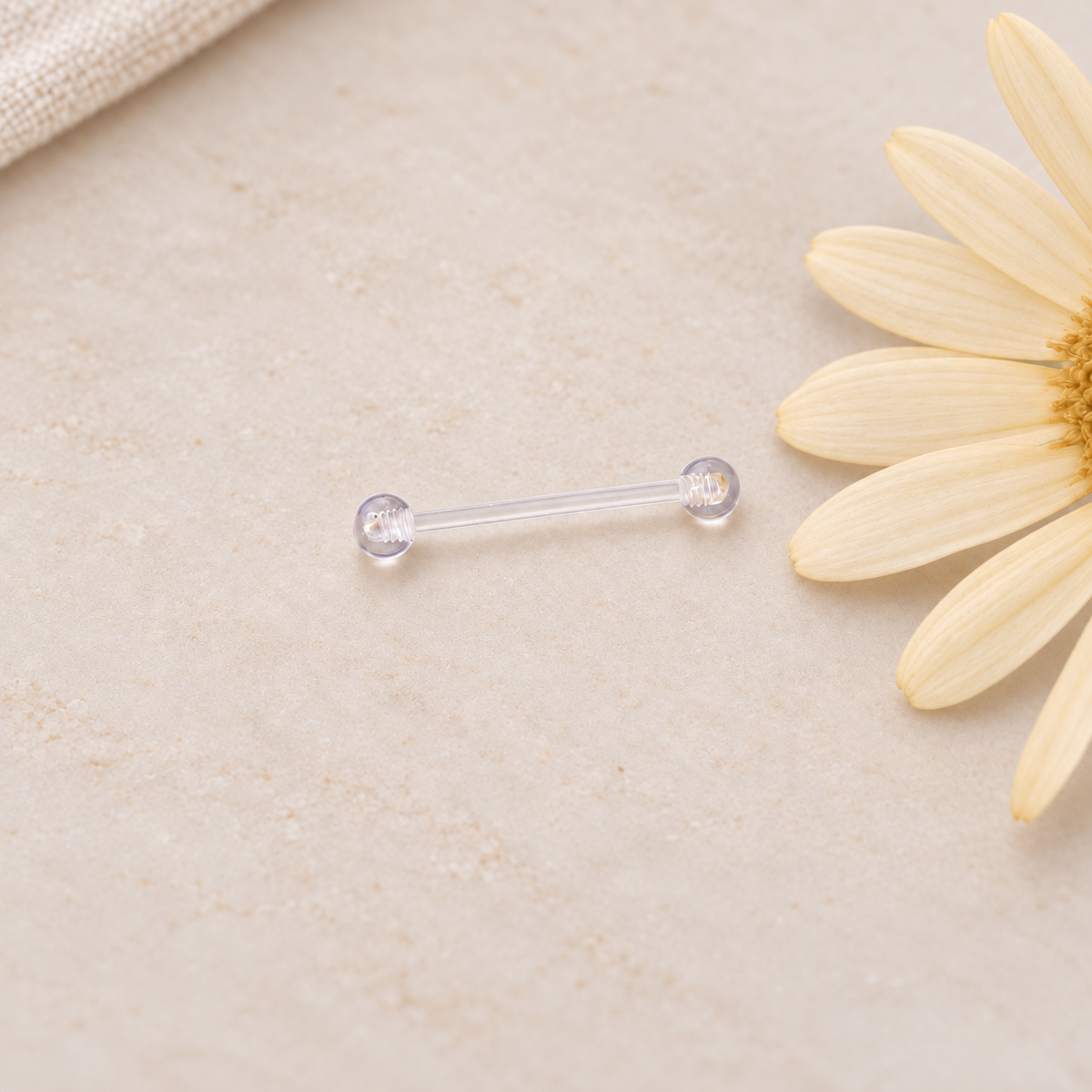 Clear nipple retainer barbell on a neutral surface