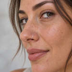Clear nose ring retainer worn in the nostril, close-up