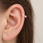 Clear horseshoe piercing retainer shown on the ear