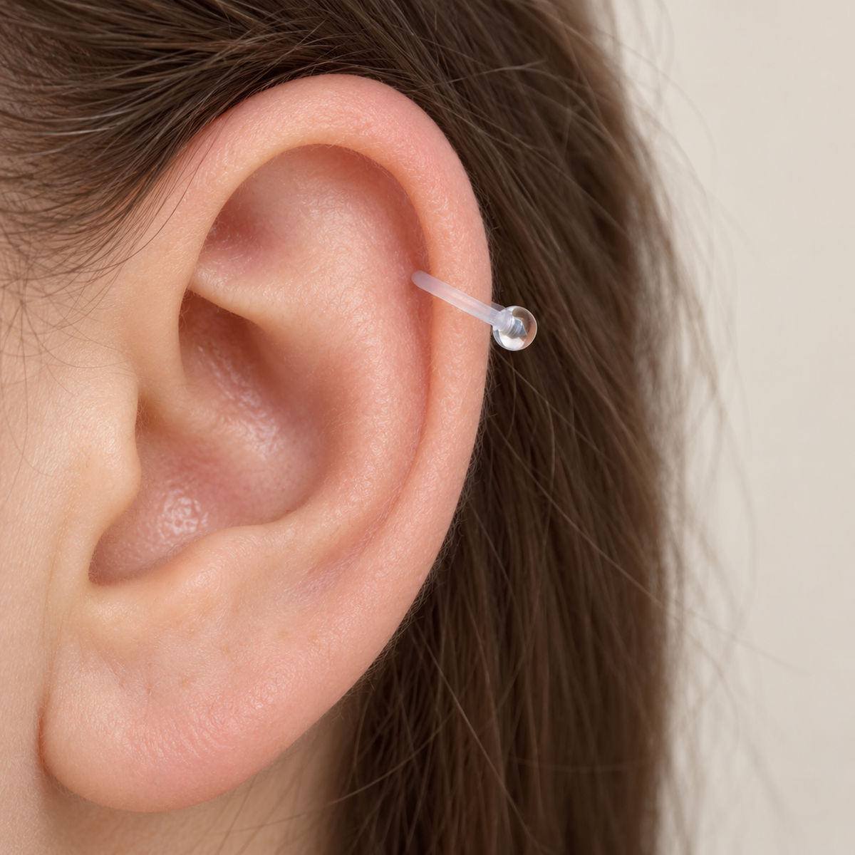 Clear horseshoe piercing retainer shown on the ear