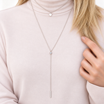 Silver disc lariat necklace worn with a light top