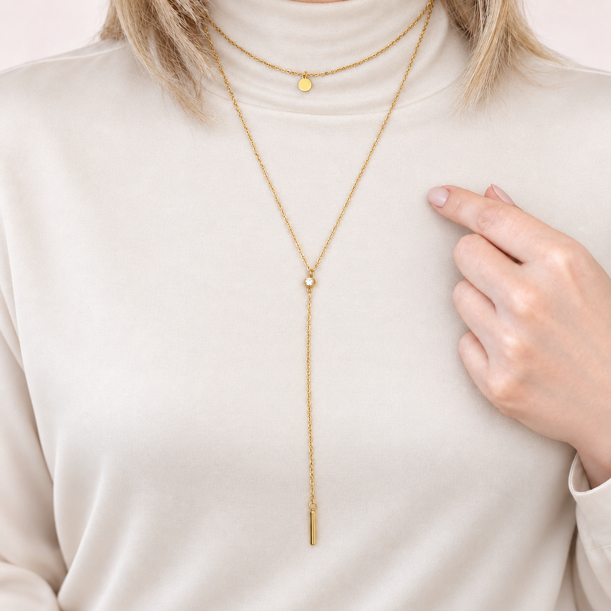 Gold disc lariat necklace worn with a light top