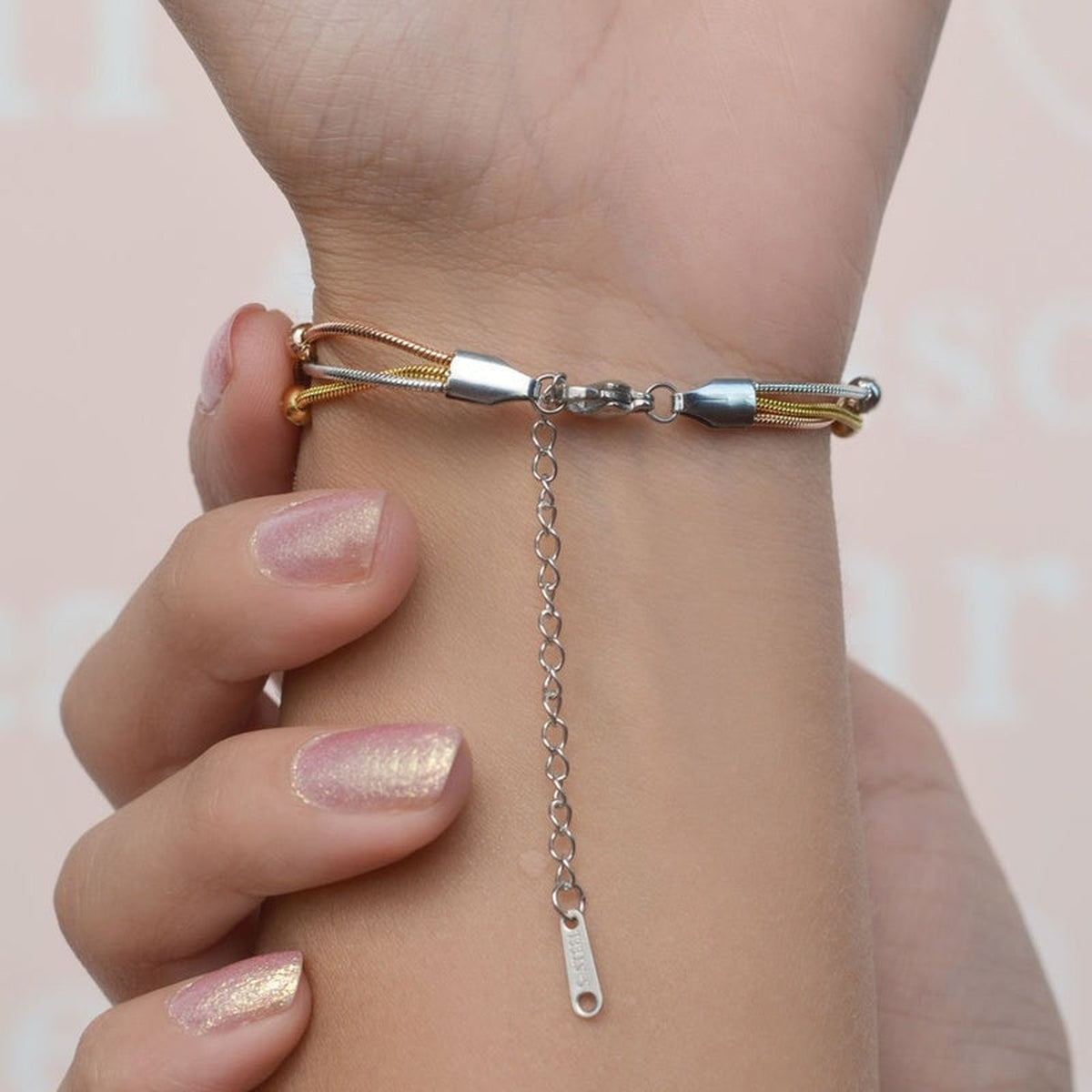 Adjustable extension chains on a set of three beaded bracelets worn on the wrist