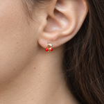 Close-up of a red cherry earring worn on the ear — Toku LONDON