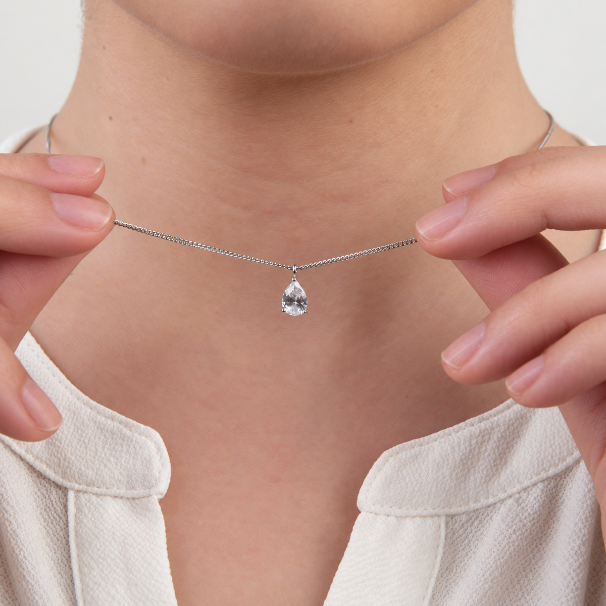 Solitaire pendant necklace held while worn