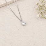 Zircon solitaire pendant necklace on cream background