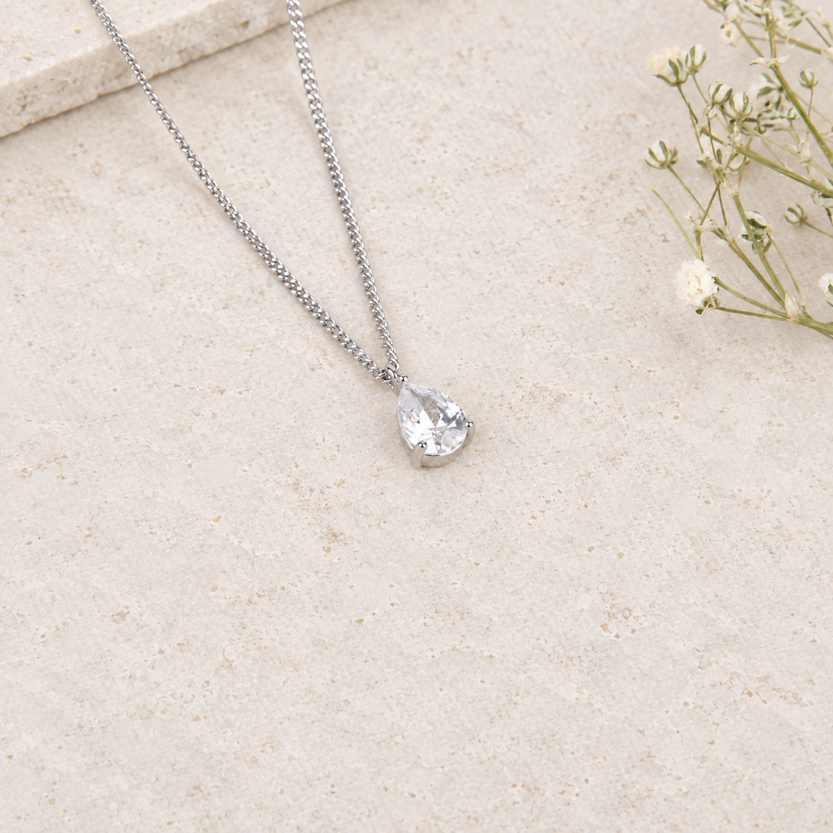 Zircon solitaire pendant necklace on cream background