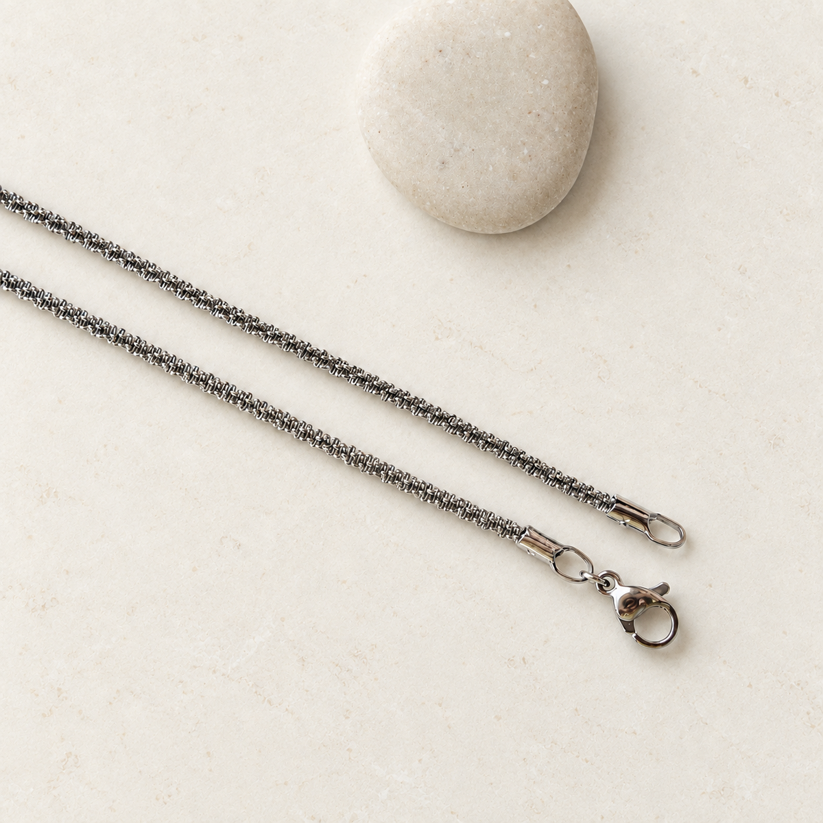 Silver glitter chain necklace with clasp and extension chain on a light background