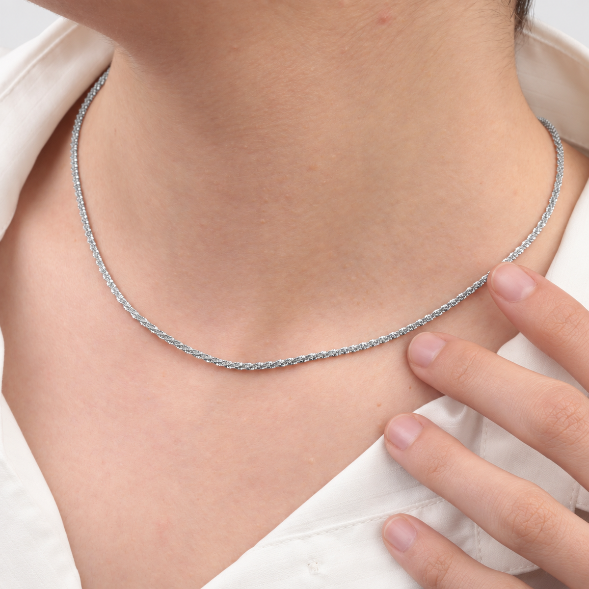 Close-up of silver glitter chain necklace worn at the neckline