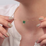Gold green clover pendant necklace held while worn