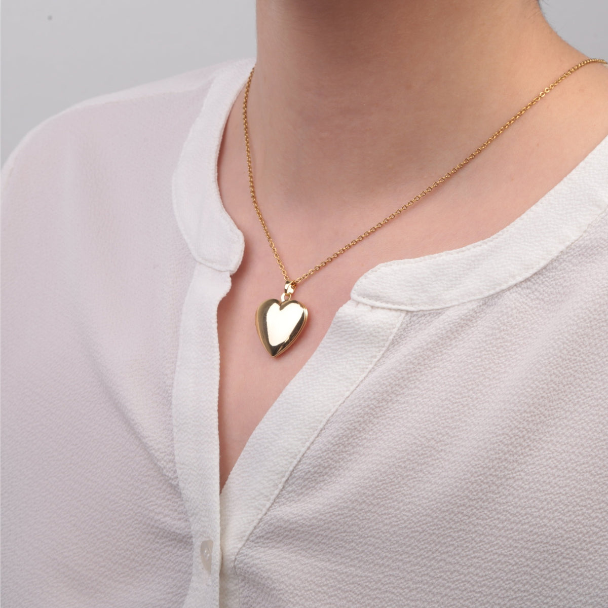 Gold heart photo locket necklace worn