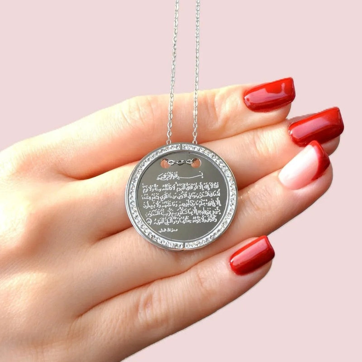 Silver Ayatul Kursi round pendant necklace held in hand