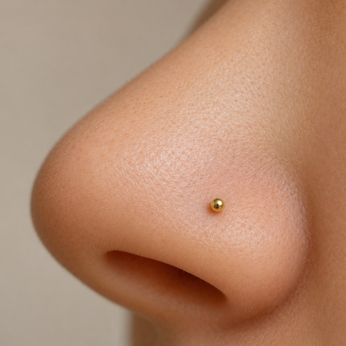 Gold ball nose stud worn, close-up