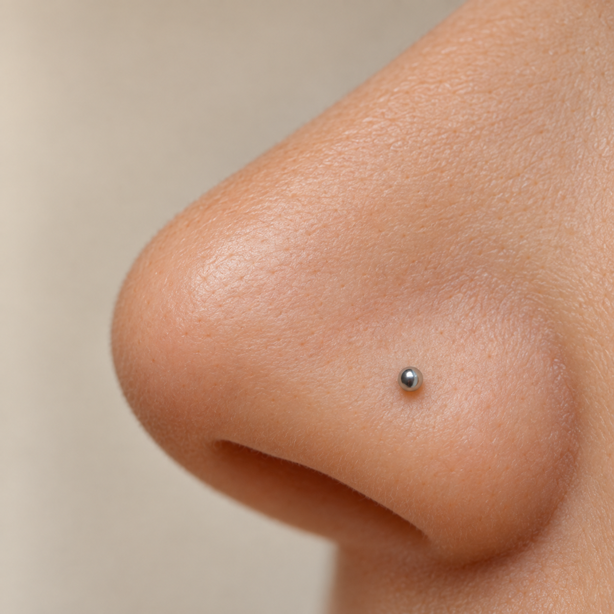 Silver ball nose stud worn, close-up