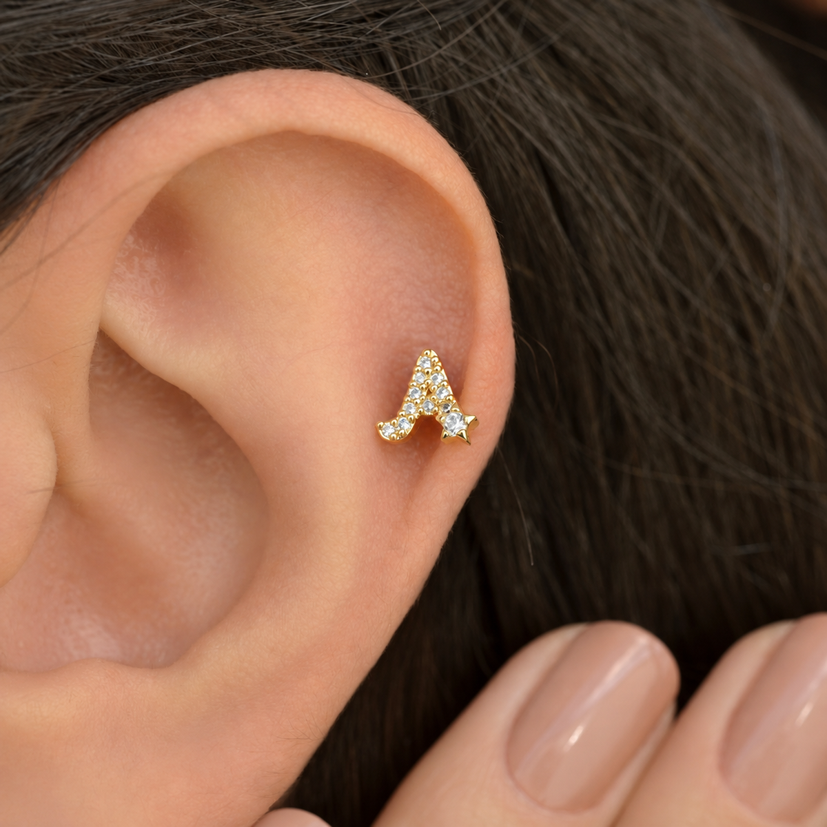 Gold zircon letter A piercing stud shown on the ear
