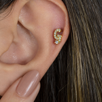 Gold zircon letter G piercing stud shown on the ear