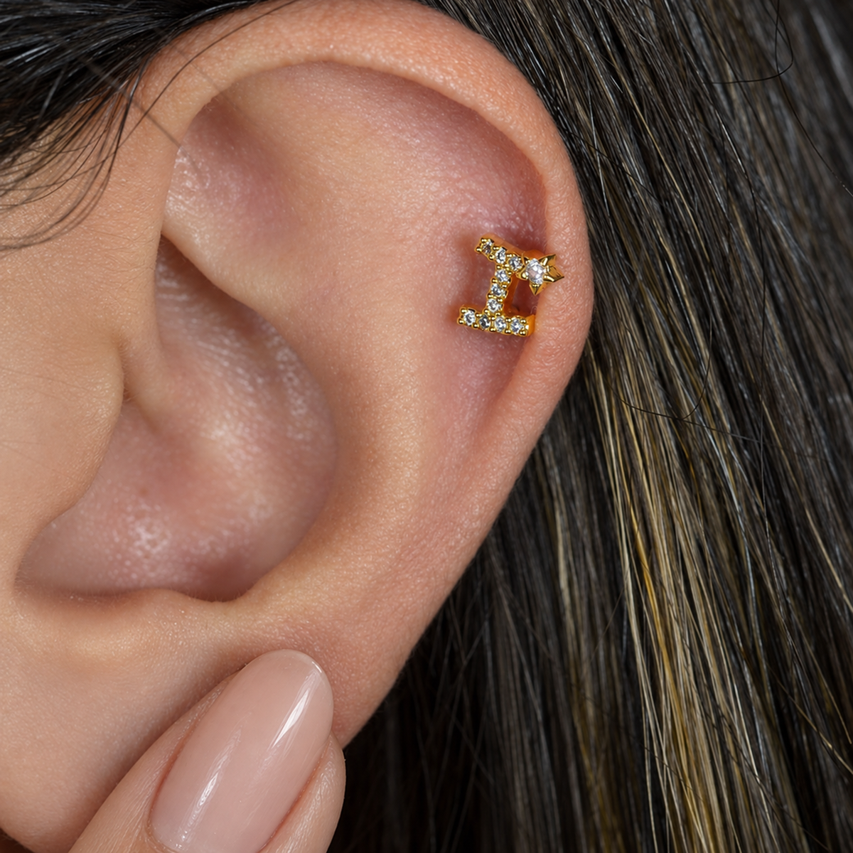 Gold zircon letter I piercing stud shown on the ear