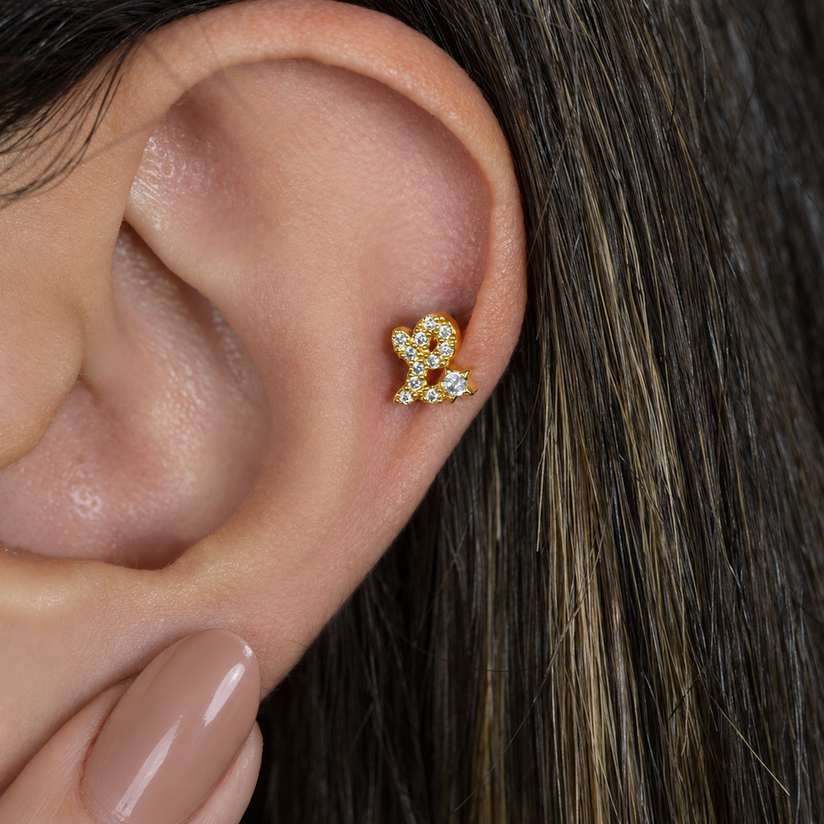 Gold zircon letter L piercing stud shown on the ear