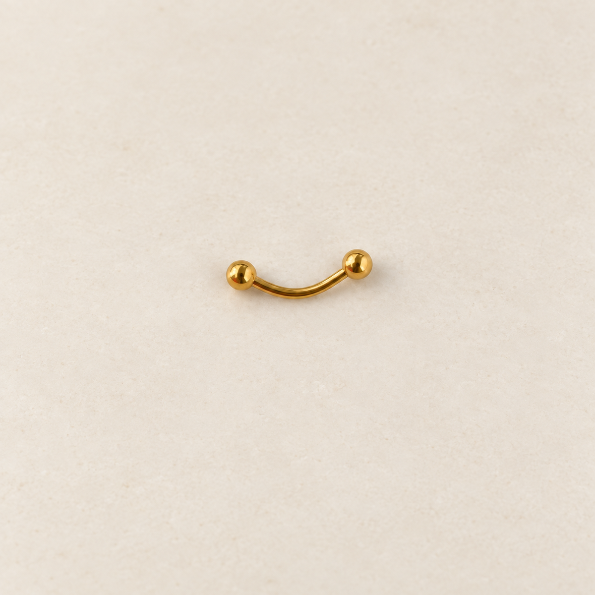 Gold curved barbell with ball ends