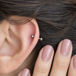 Silver curved barbell shown on the ear, side view