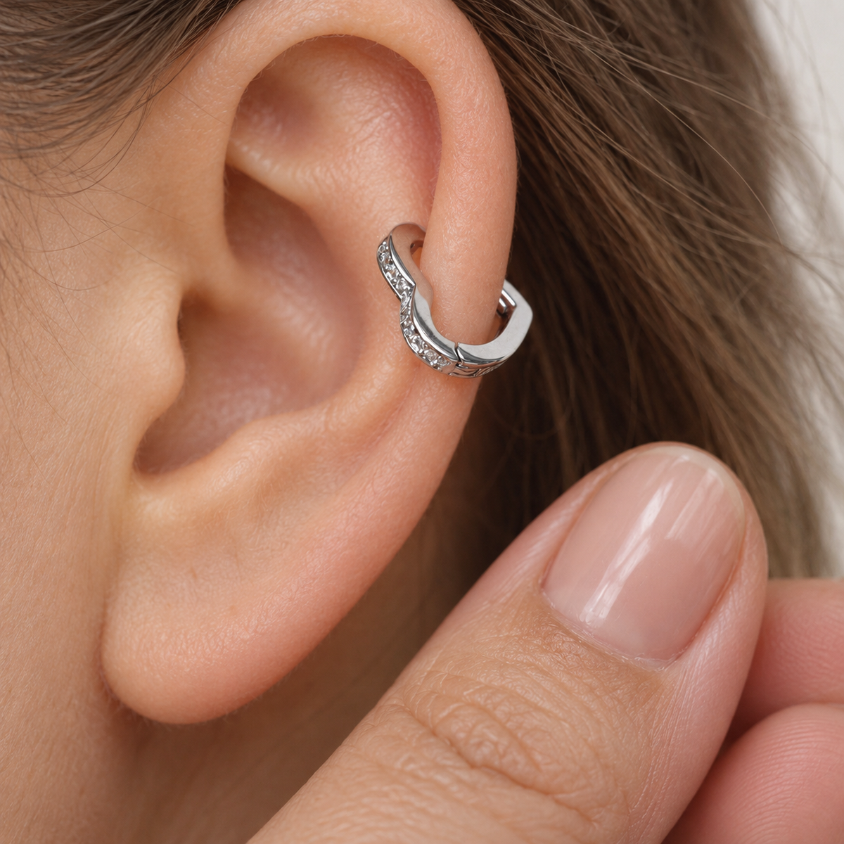Silver heart-shaped hoop earring shown on the ear — Toku LONDON