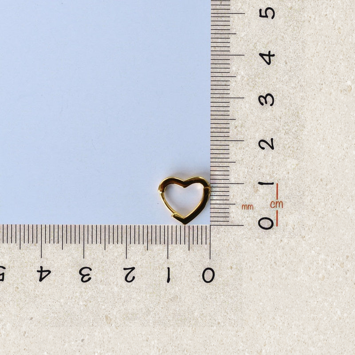 Heart-shaped hoop earring beside a ruler for size reference — Toku LONDON