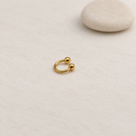 Gold ball-end horseshoe barbell on a neutral background