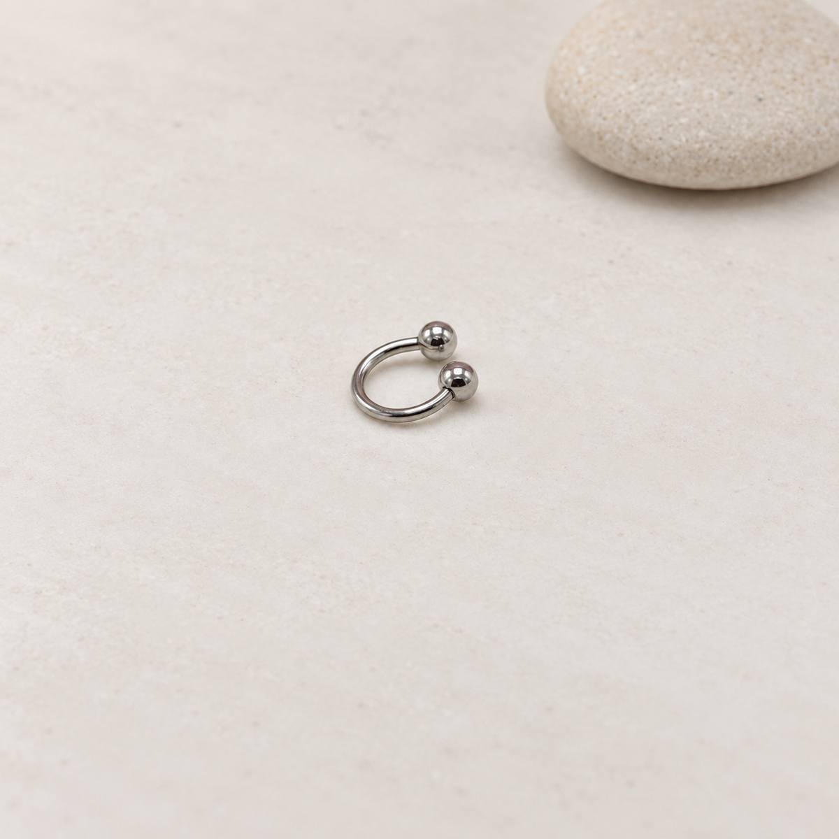 Silver ball-end horseshoe barbell on a neutral background