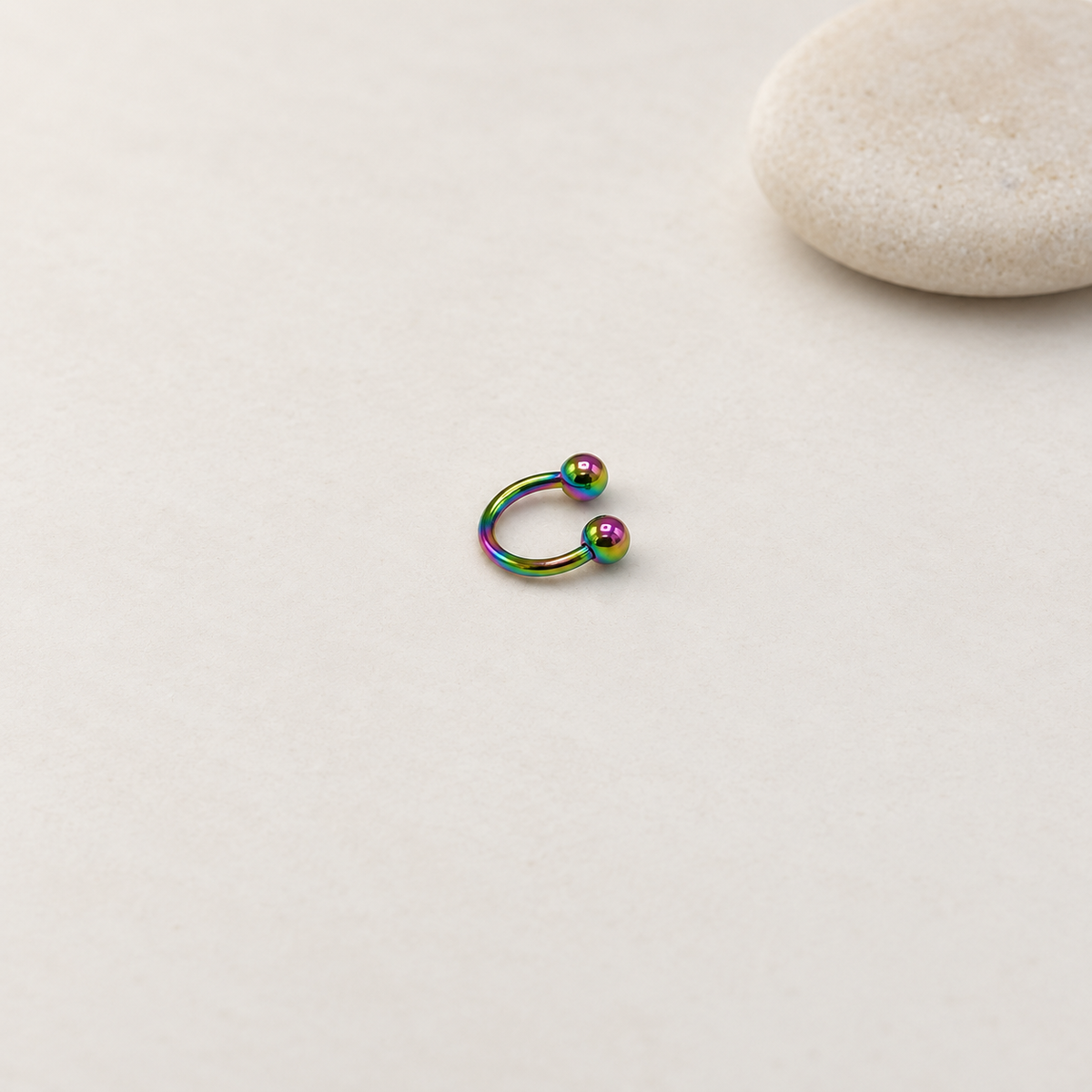 Rainbow ball-end horseshoe barbell on a neutral background