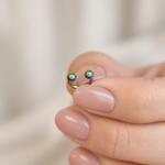 Rainbow horseshoe barbell held between fingers
