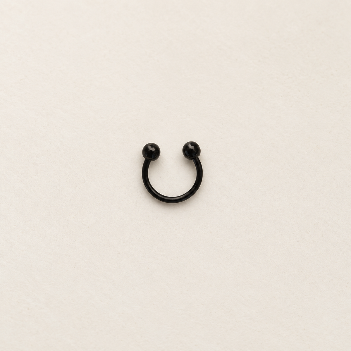 Black ball-end horseshoe barbell on a neutral background