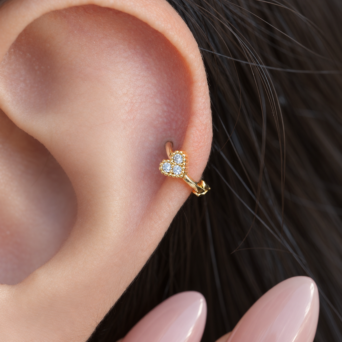 Gold mini heart hoop earring worn in helix piercing