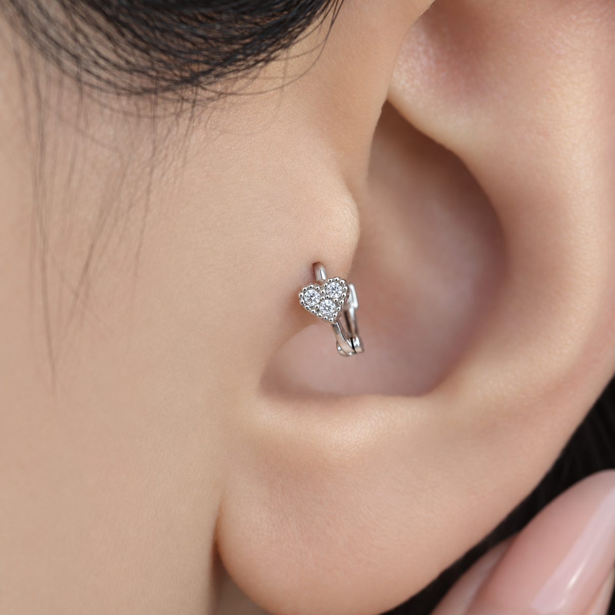Silver mini heart hoop earring worn in tragus piercing