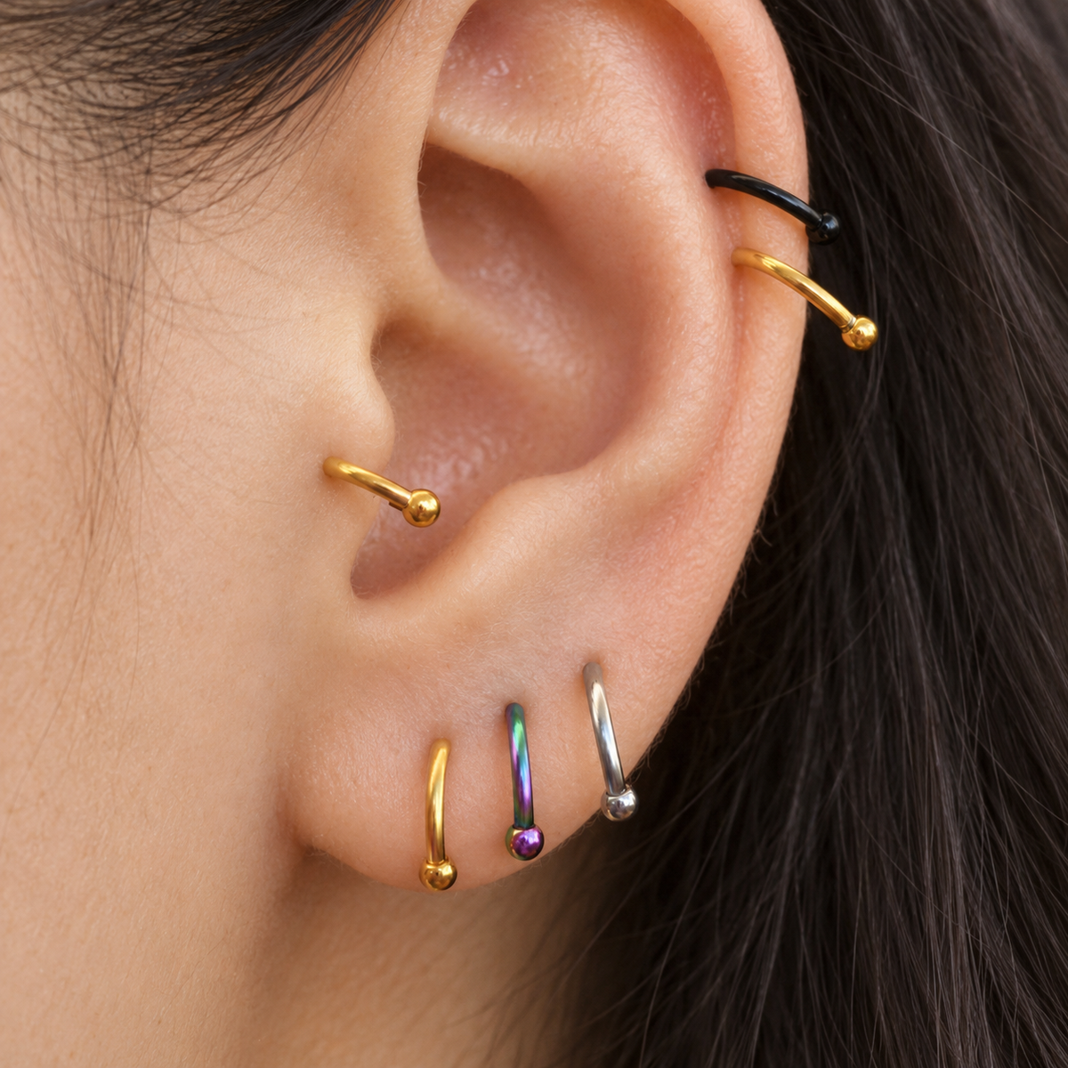 Mini horseshoe circular barbells worn in ear piercings
