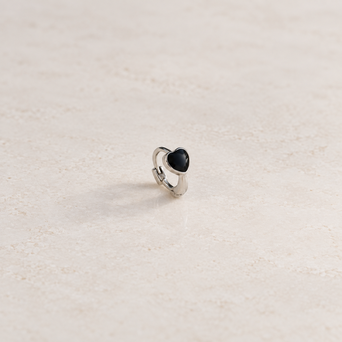 Silver hoop ring with a black heart