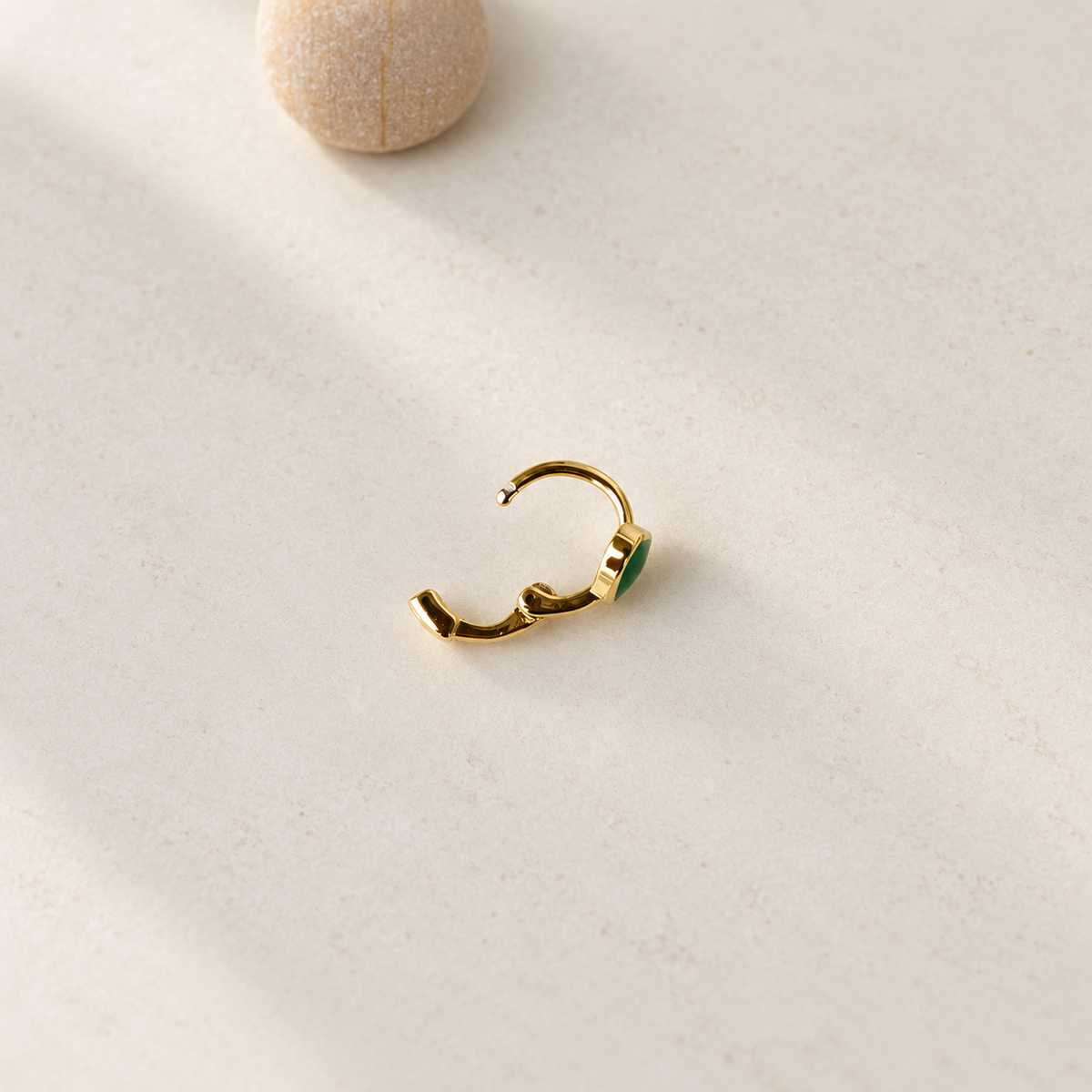 Gold hoop ring with a green heart, open view