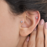 Silver solitaire studs shown worn on the ear — Toku LONDON