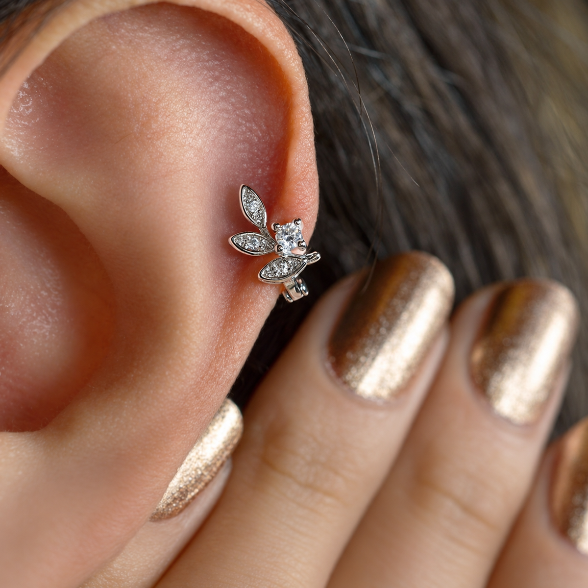 Silver leaf hoop earring worn in helix piercing