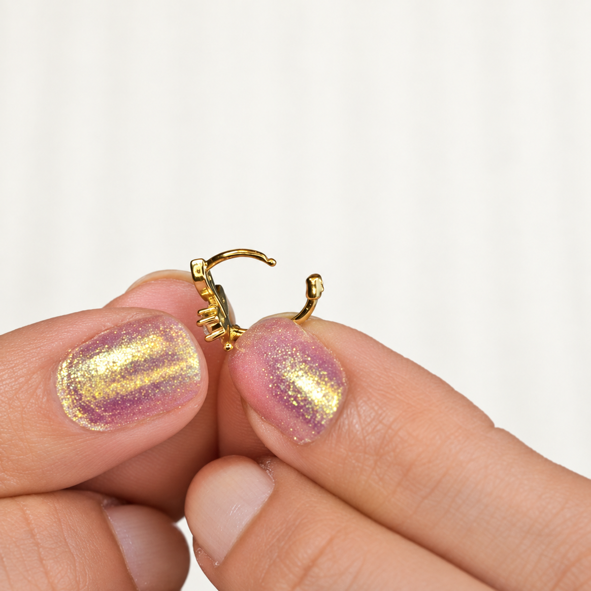 Gold leaf hoop earring held open