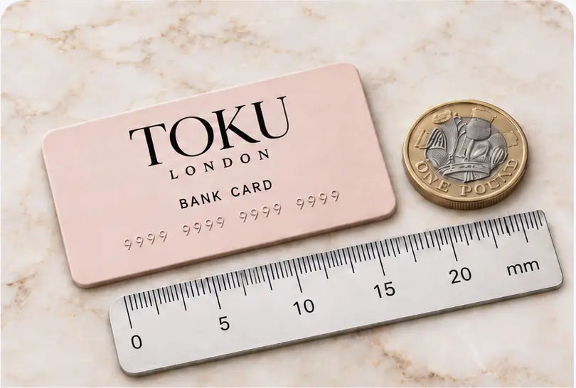 Toku LONDON bank card with small embossed 9s beside a British coin and millimetre ruler