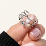 Silver-tone three-band ring with clear-stone stars and a crescent moon held against a fingertip.